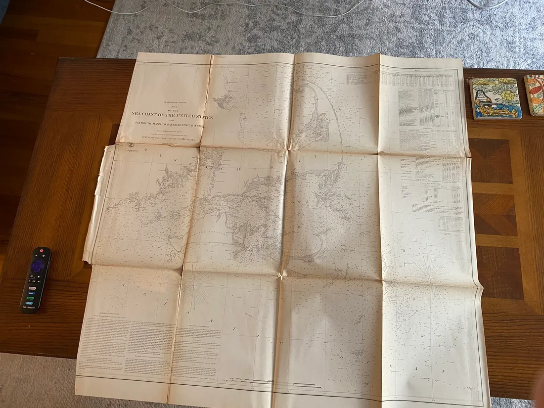 Large Massachusetts sea coast survey print unfolded on a wooden table