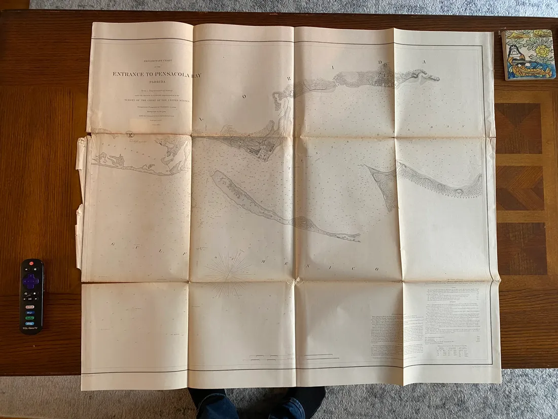 Large Entrance to Pensacola Bay survey print unfolded on a wooden table